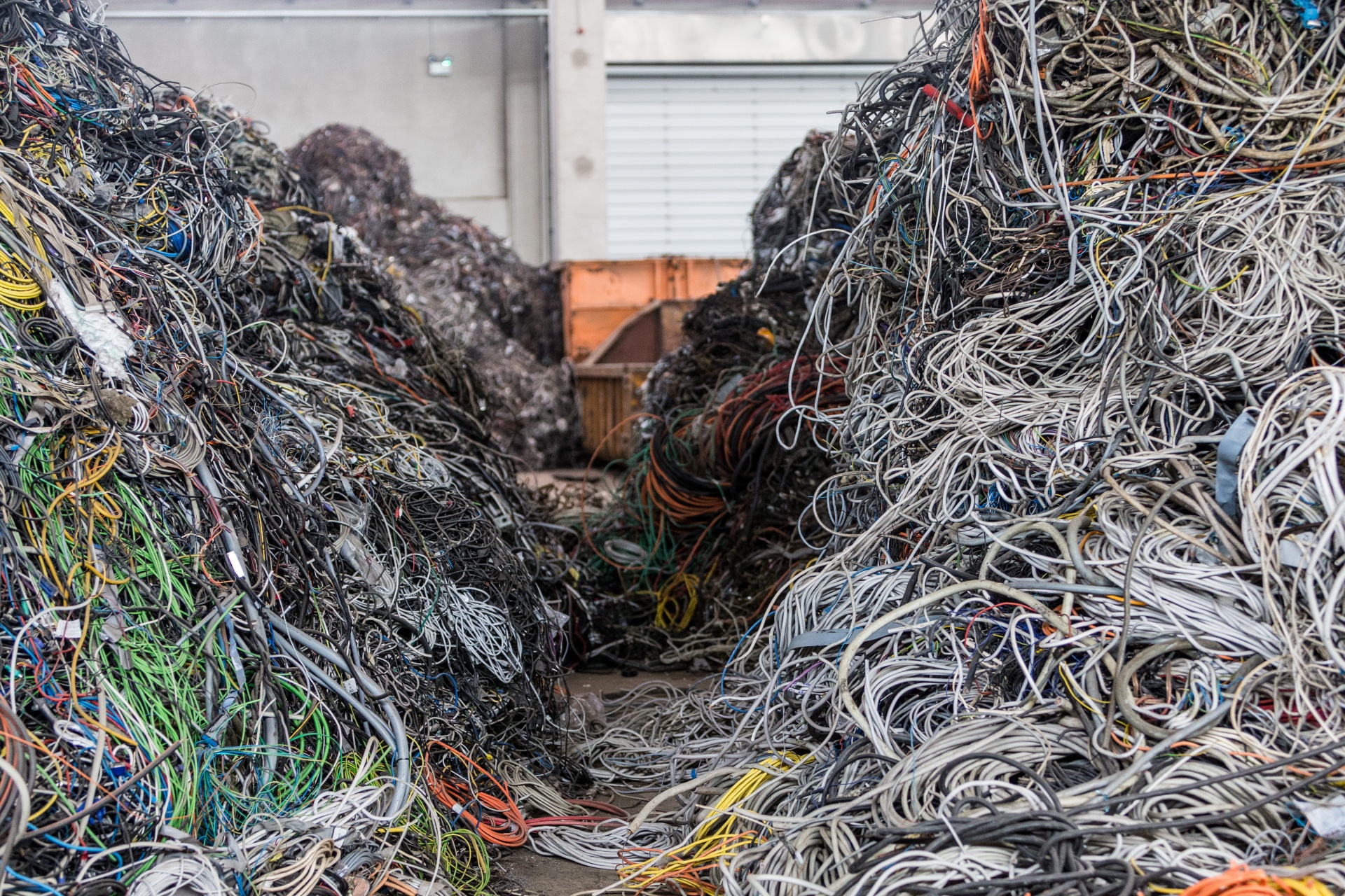Die Sicht auf zwei gemischte und bunte Abfallhaufen von Elektro- und Kabelrecycling.